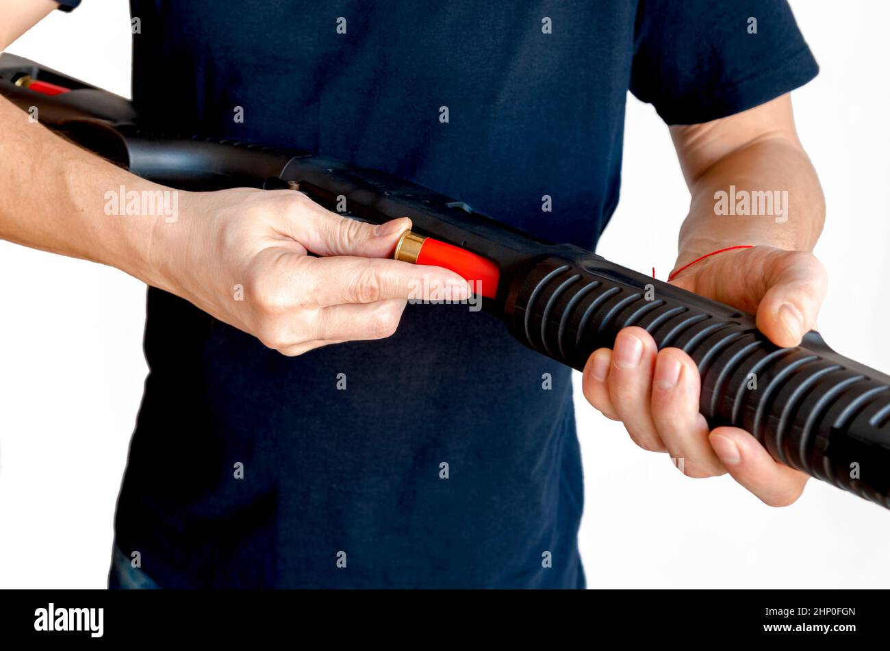 Nahaufnahme eines Mannes, der eine rote Schrotflinte in das Magazin seiner Waffe geladen hat. Laden einer Glattbore-Waffe der Pumpe Stockfoto