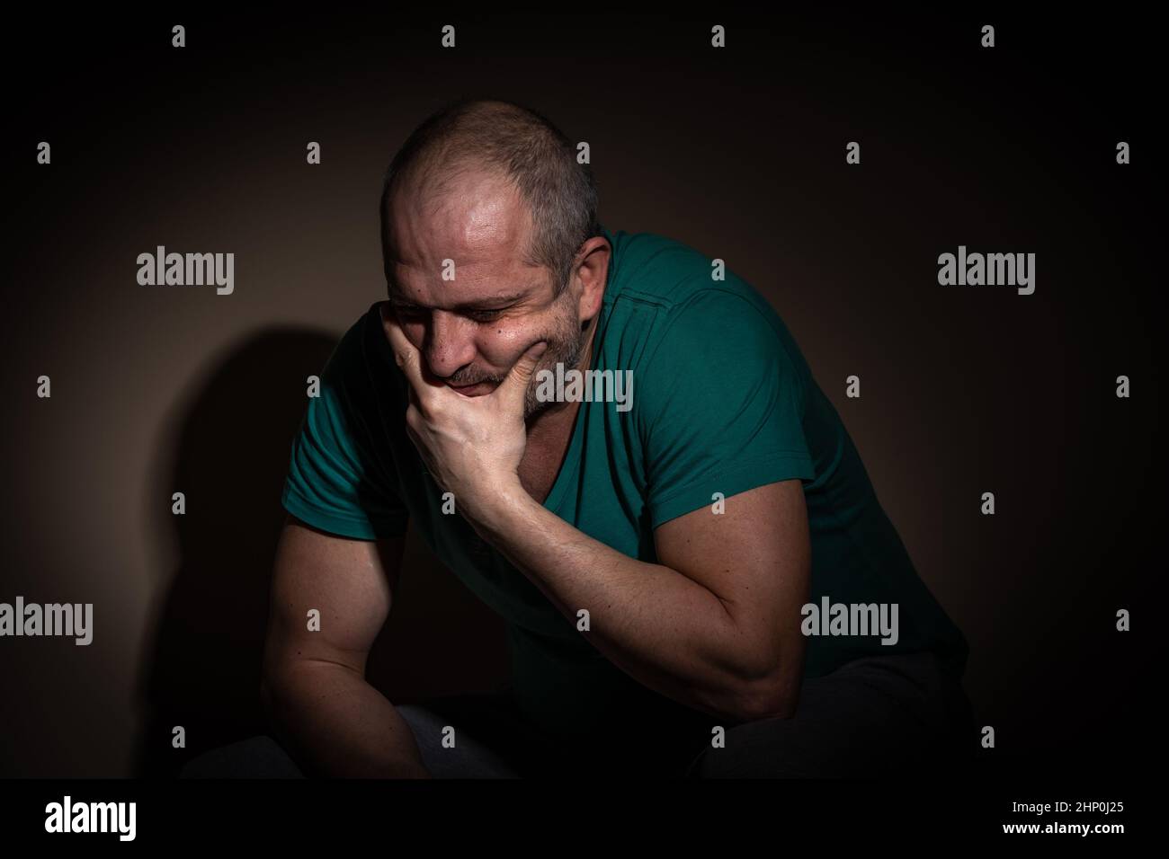 Mann im mittleren Alter, der unter Angst, Depressionen aufgrund sozialer Abgeschiedenheit, Isolation, Folge von covid-19 leidet Stockfoto