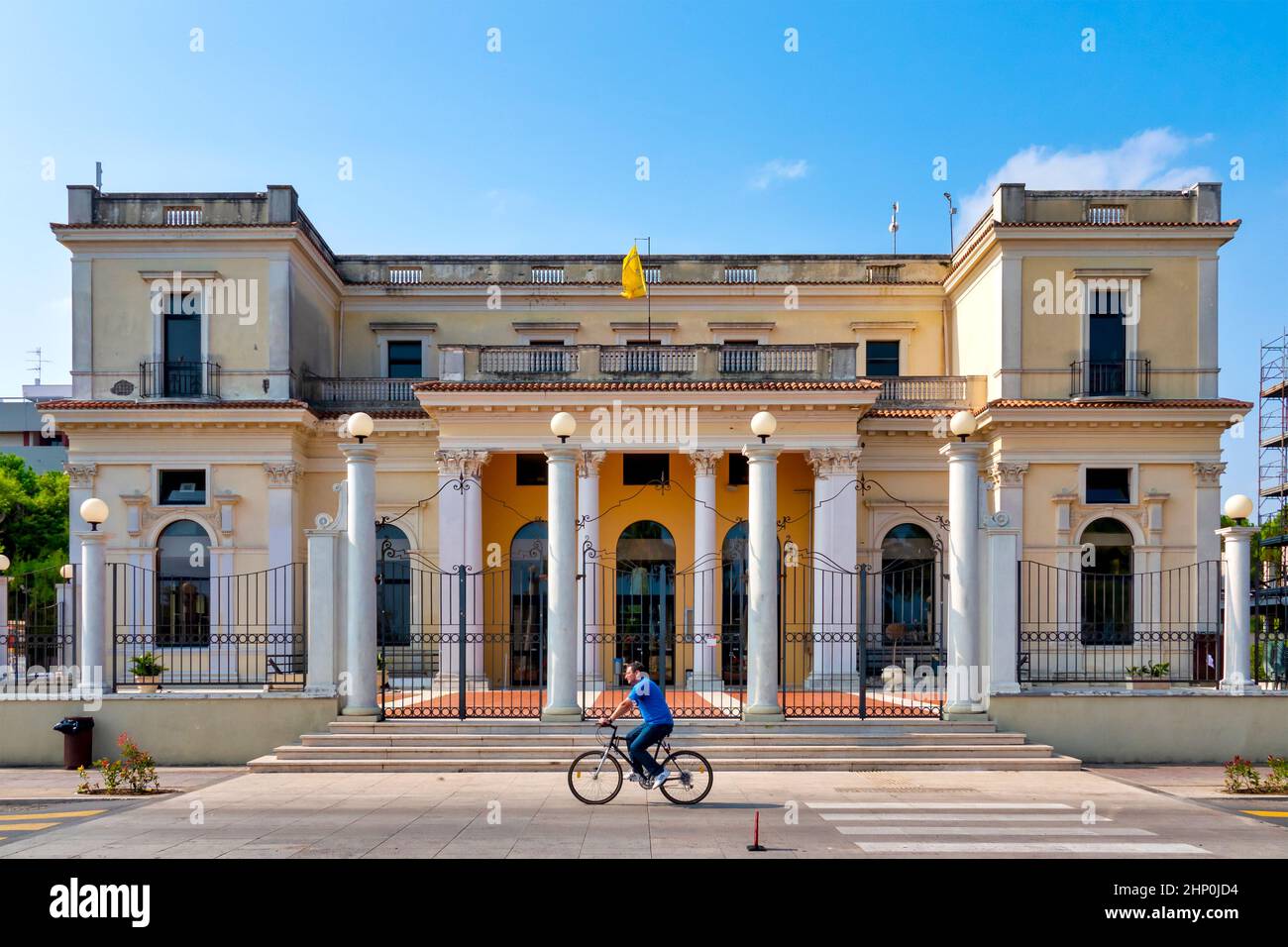 Ein Mann, der mit dem Fahrrad vor dem Palazzo Kursaal, Giulianova, Italien, fährt Stockfoto