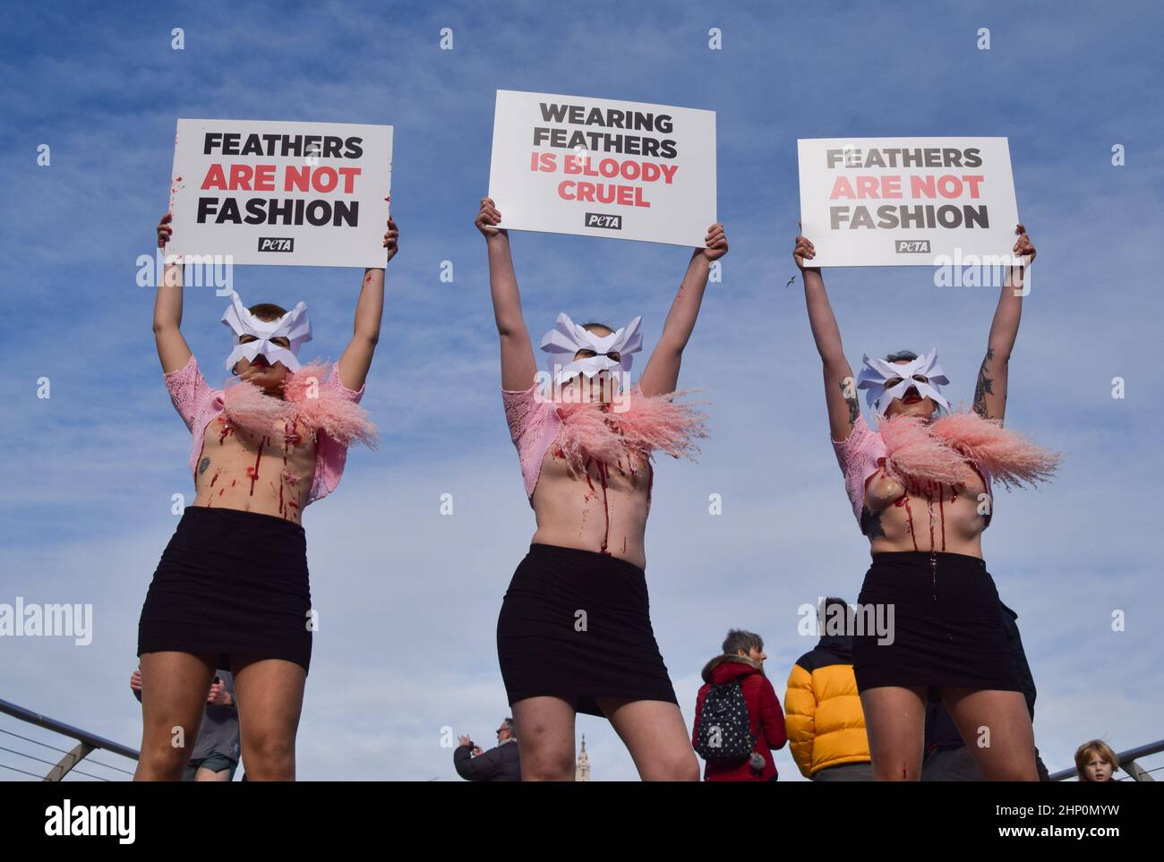 London, Großbritannien. 17th. Februar 2022. PETA-Aktivisten mit Vogelmasken und freigelegten „blutigen und gerupften“ Truhen inszenierten auf der Millennium Bridge einen „Laufsteg“, um gegen den Einsatz von Vogelfedern in Kleidungsstücken und Accessoires auf der London Fashion Week zu protestieren. Stockfoto