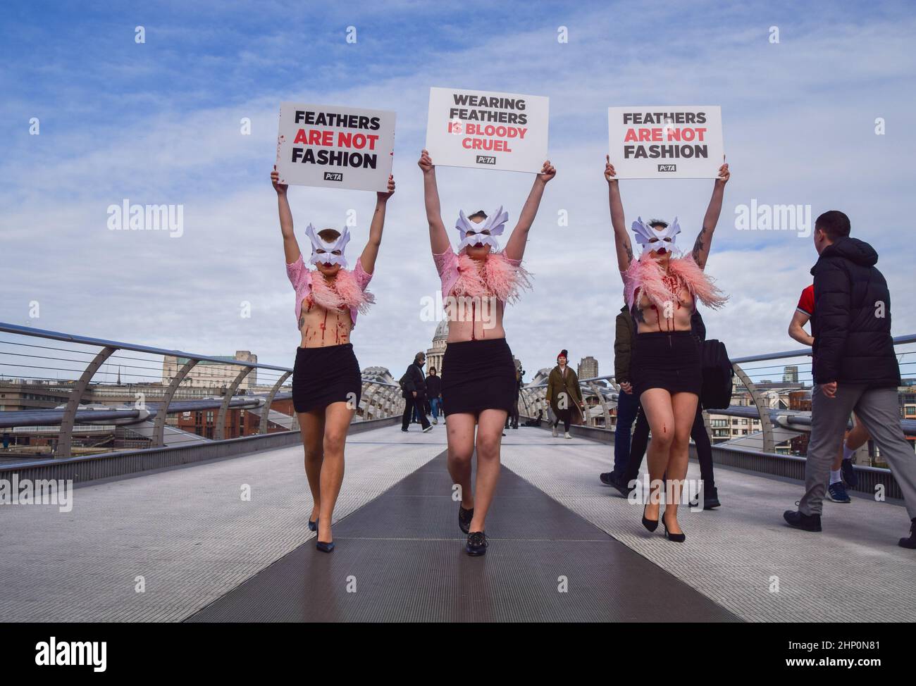 London, Großbritannien. 17th. Februar 2022. PETA-Aktivisten mit Vogelmasken und freigelegten „blutigen und gerupften“ Truhen inszenierten auf der Millennium Bridge einen „Laufsteg“, um gegen den Einsatz von Vogelfedern in Kleidungsstücken und Accessoires auf der London Fashion Week zu protestieren. Stockfoto