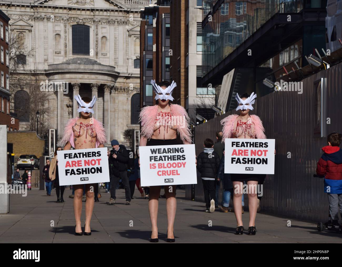 London, Großbritannien. 17th. Februar 2022. PETA-Aktivisten mit Vogelmasken und freigelegten „blutigen und gerupften“ Truhen inszenierten auf der Millennium Bridge einen „Laufsteg“, um gegen den Einsatz von Vogelfedern in Kleidungsstücken und Accessoires auf der London Fashion Week zu protestieren. Stockfoto