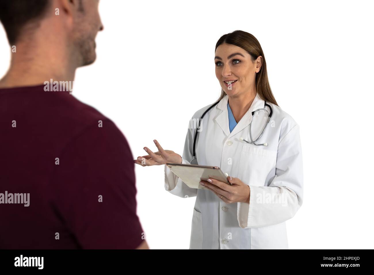 Lächelnde kaukasische Ärztin mit Laborkittel und Stethoskop mit digitalem Tablet und männlichem Pati Stockfoto