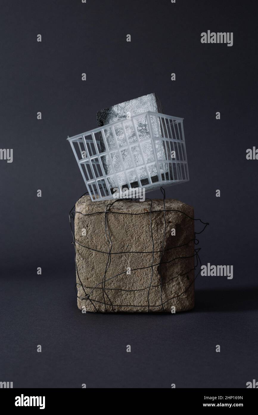 Zeitgenössische Stillleben Kunst Skulptur mit einem Plastikkorb mit einem Schleifschwamm, Stein mit Metalldraht Stockfoto