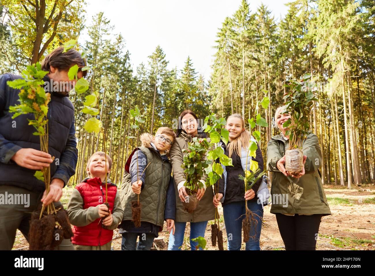 Familie und Förster mit Baumauswahl für nachhaltige ökologische Wiederaufforstung im Wald Stockfoto