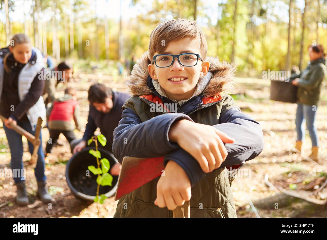 Glücklicher Junge helfen seiner Familie Pflanzenbaum für Umweltschutz und Ökologie Stockfoto