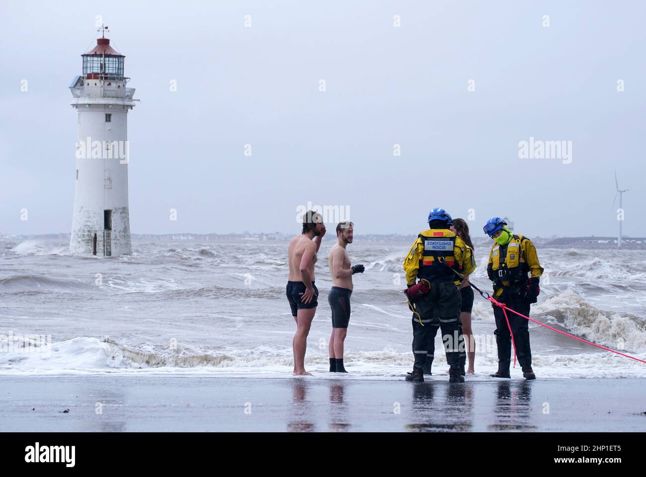 Ein Such- und Rettungsteam der Küstenwache bittet eine Gruppe von Schwimmern, in New Brighton, Merseyside, aus dem Meer zu kommen, während der Sturm Eunice die Südküste trifft, wobei die Attraktionen schließen, die Reise unterbrochen wird und in einigen Gebieten ein schwerer Vorfall gemeldet wird, was bedeutet, dass die Menschen gewarnt werden, drinnen zu bleiben. Eine seltene rote Wetterwarnung - die höchste Warnung, was bedeutet, dass ein hoher Aufprall sehr wahrscheinlich ist - wurde vom Met Office aufgrund der Kombination aus hohen Gezeiten, starken Winden und Sturmfluten ausgegeben. Bilddatum: Freitag, 18. Februar 2022. Stockfoto