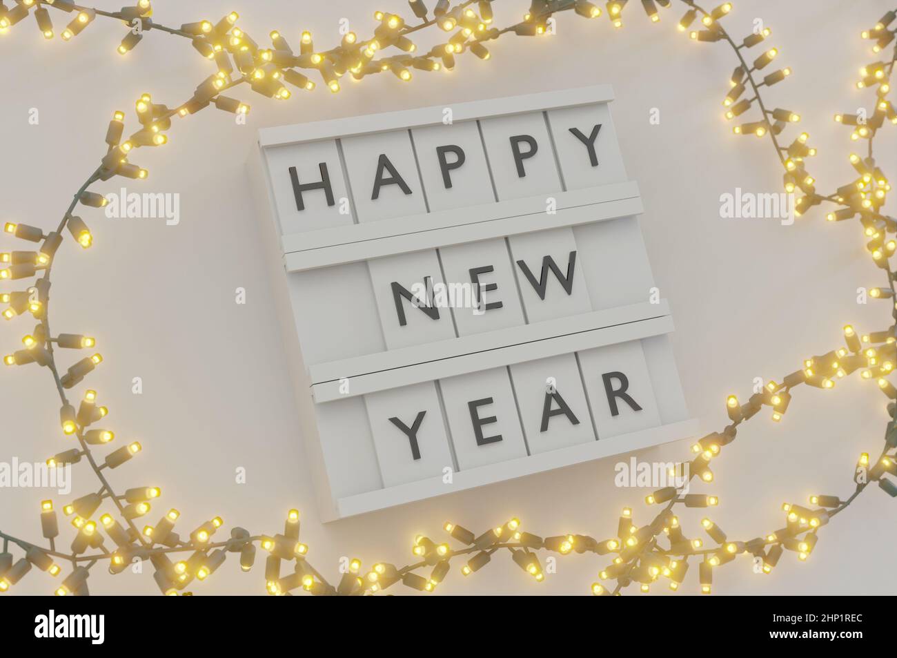 3D Abbildung. Happy New Year Text Light Box und glühende Glühbirnen Weihnachten und Neujahr auf weißem Hintergrund . Speicherplatz Für Nachricht Kopieren. Stockfoto