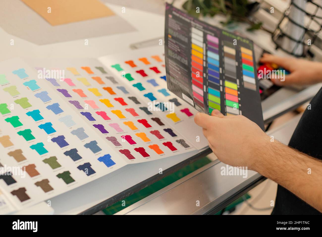 Cropped Mann Hände Auswahl Proben Katalog Palette Rack Farbe Werbung T-Shirts Palette Film Membran. Nahaufnahme Stockfoto