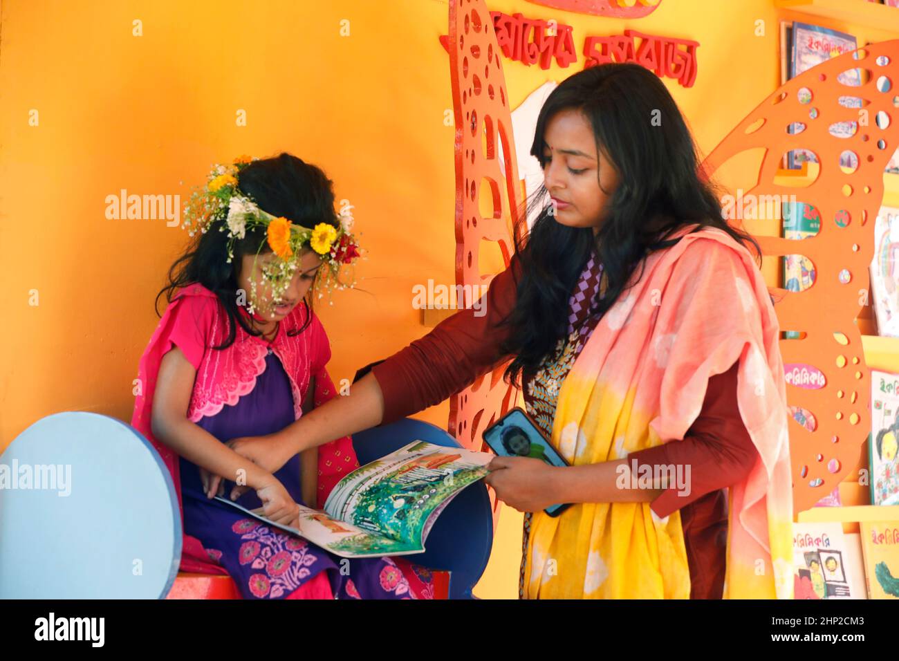 Dhaka, Bangladesch - 18. Februar 2022: Besucher der Buchmesse schauen sich Bücher an. Die Buchmesse Amar Ekushey in Dhaka hat am 15th. Februar begonnen Stockfoto