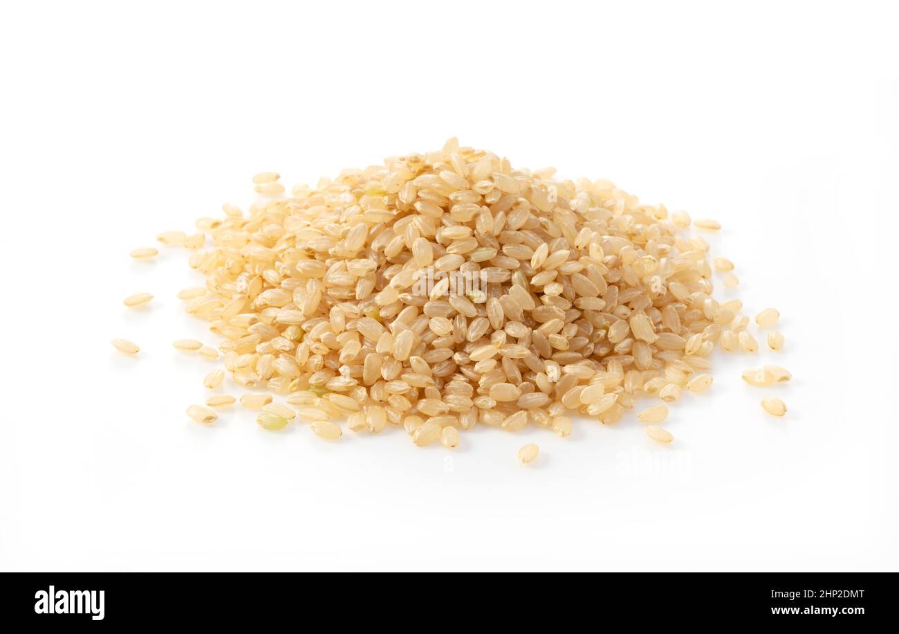 Brauner Reis auf weißem Hintergrund. Ein Haufen brauner Reis. Stockfoto