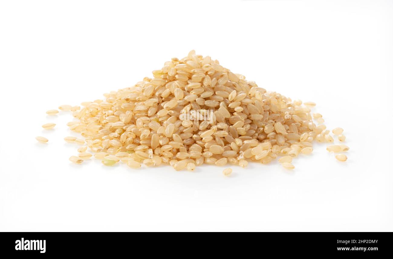 Brauner Reis auf weißem Hintergrund. Ein Haufen brauner Reis. Stockfoto