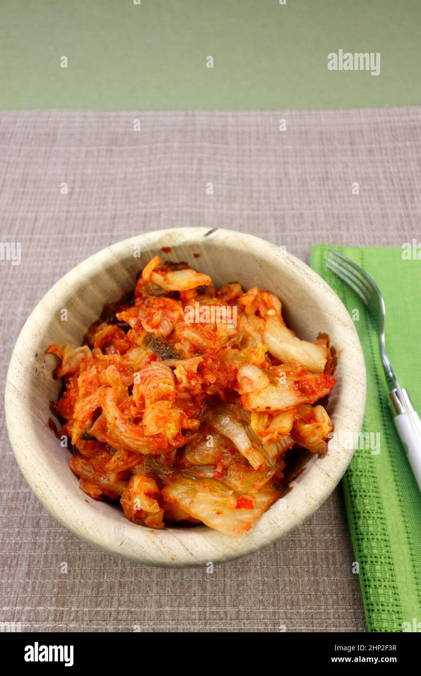 In einer Holzschüssel bereit, mit einer Gabel zu essen fermentierte Kimchi mit napa-Kohl und Rettich gemacht. Aromentiert fermentierter napa-Kohl mit Rettich und Arom Stockfoto