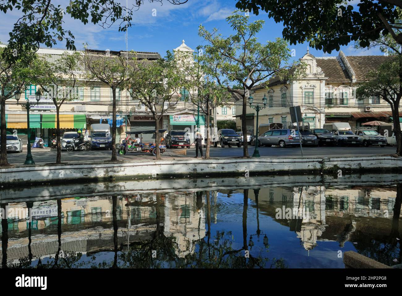 Malerische alte Lagerhäuser und Geschäfte säumen die Atsadang Road entlang des Klong (Kanal) Lod im historischen Stadtgebiet von Bangkok, Thailand, die sich im Wasser spiegeln Stockfoto