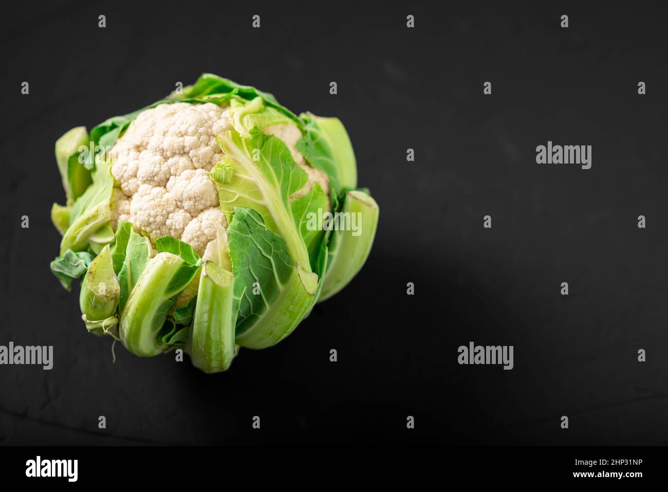 Ganzer Blumenkohl auf dunklem Hintergrund. Vegetarische Gerichte. Stockfoto