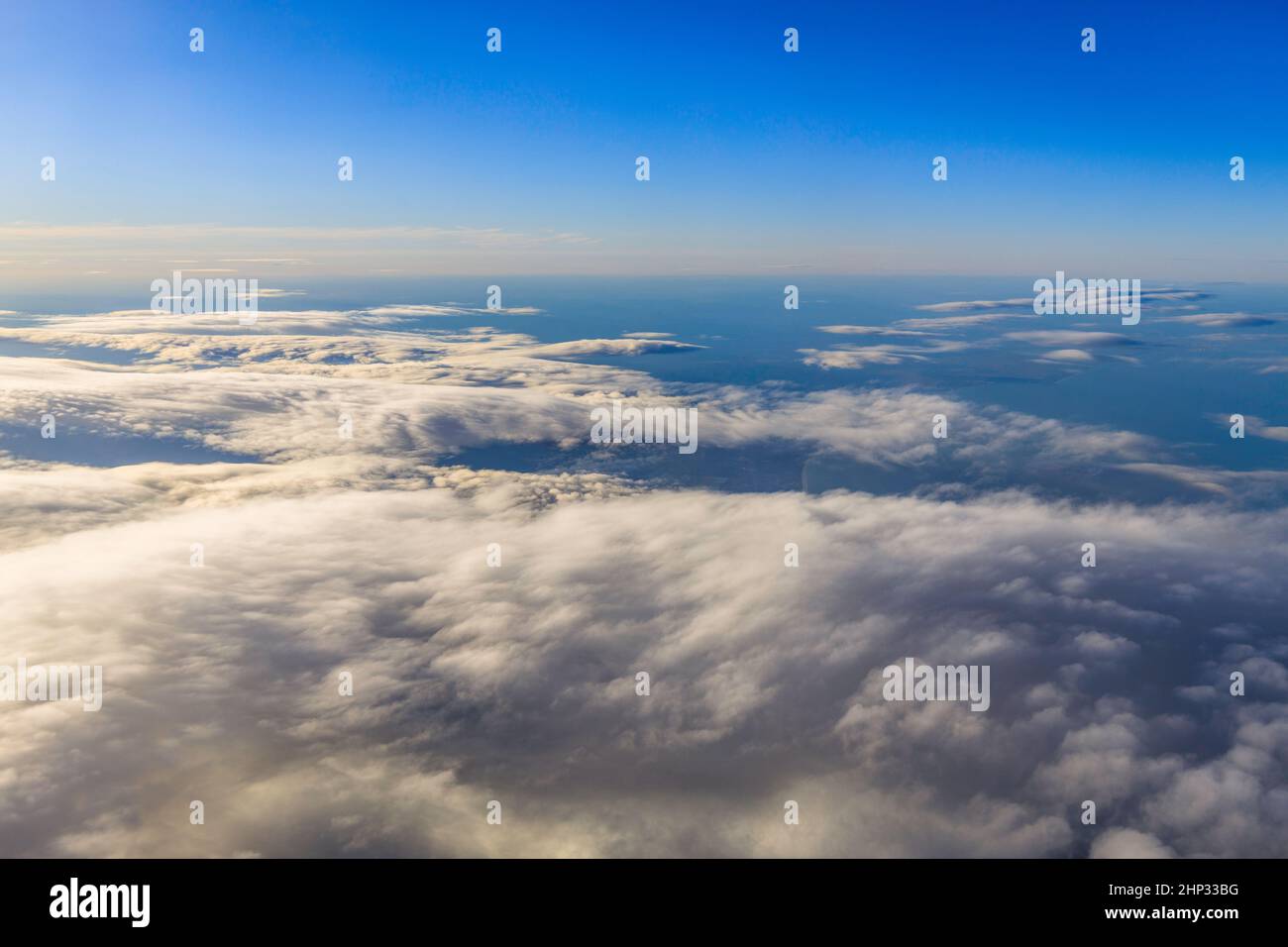 Blauer Himmel und Wolken aus dem Fenster des Flugzeugs. Stockfoto