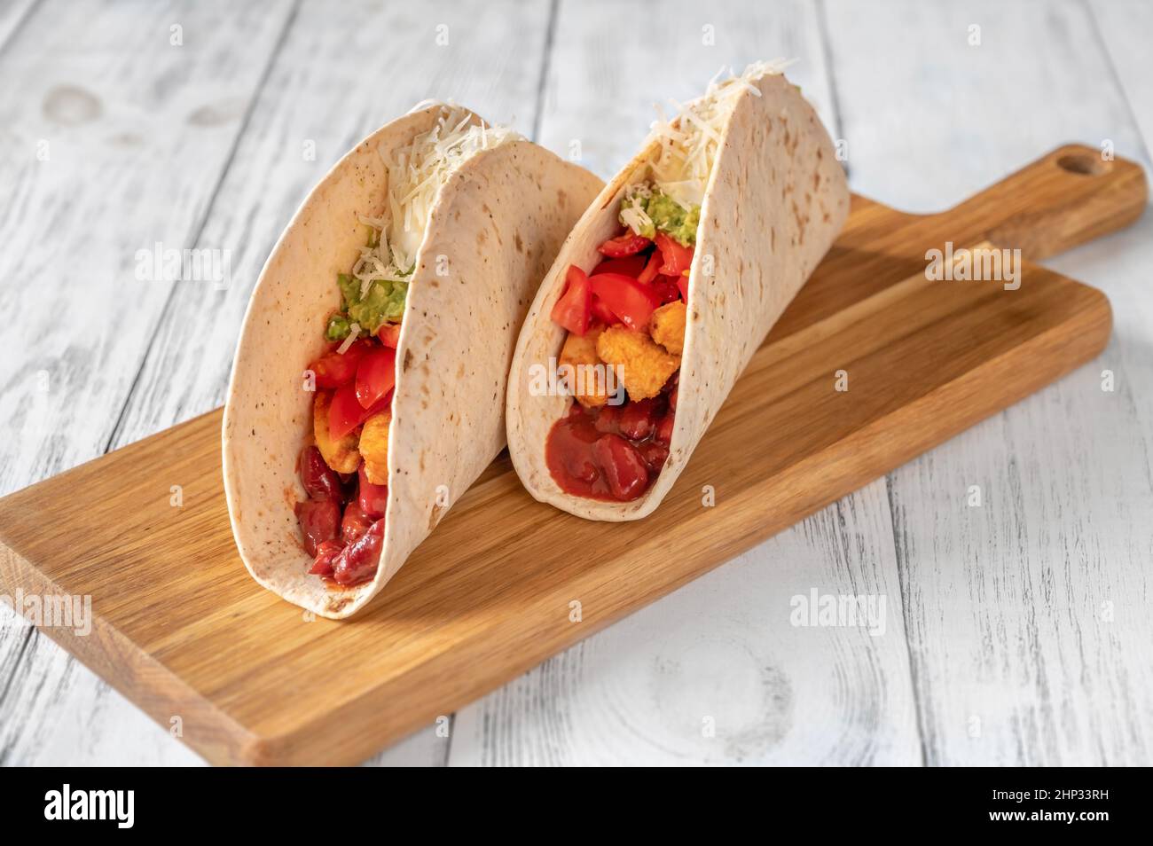 Taco mit Hühnchen- und Gemüsefüllung auf dem Holzhintergrund Stockfoto