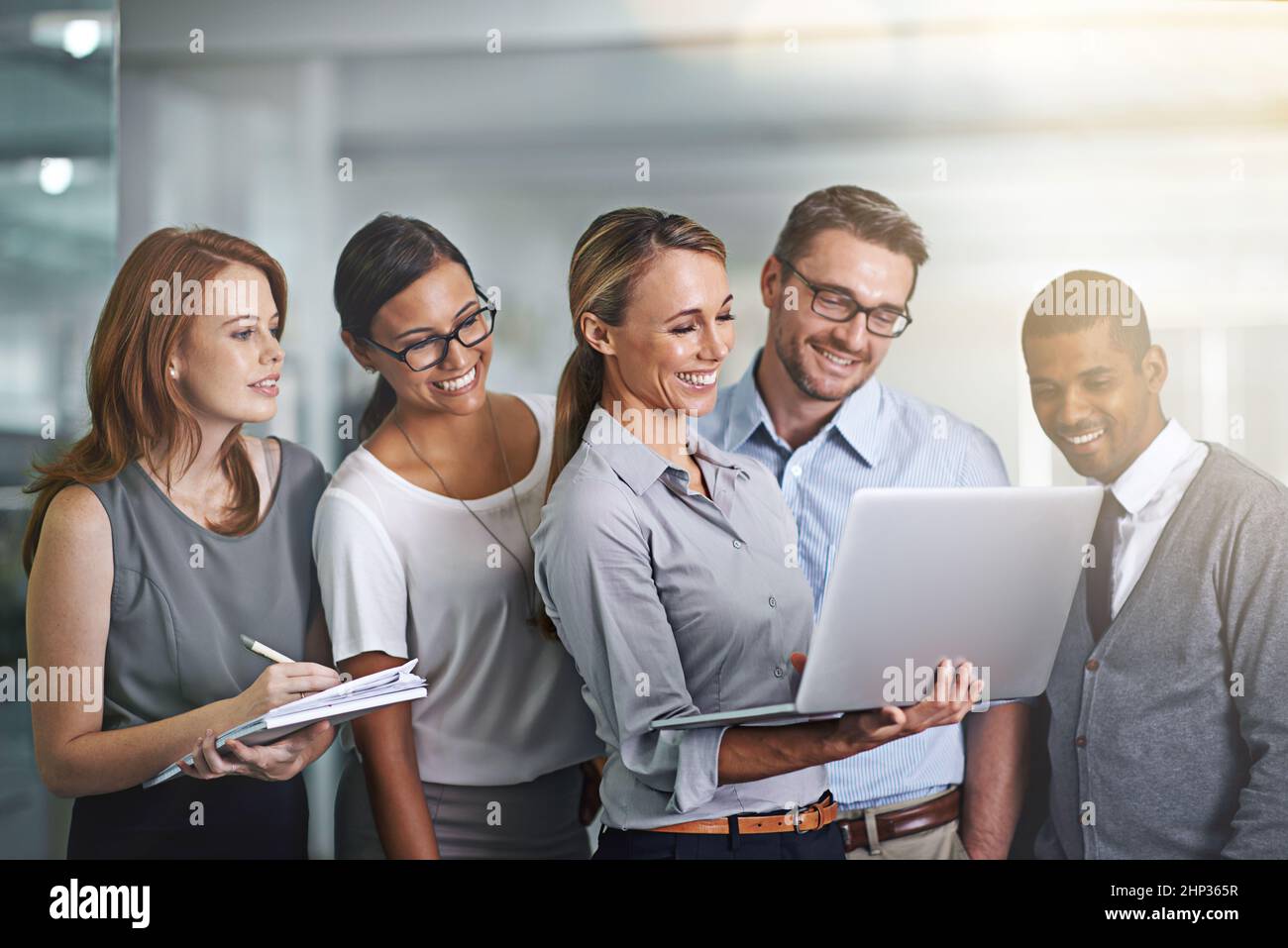 Gemeinsam erreichen alle mehr. Aufnahme eines Geschäftsteams, das zusammen an einem Laptop arbeitet. Stockfoto