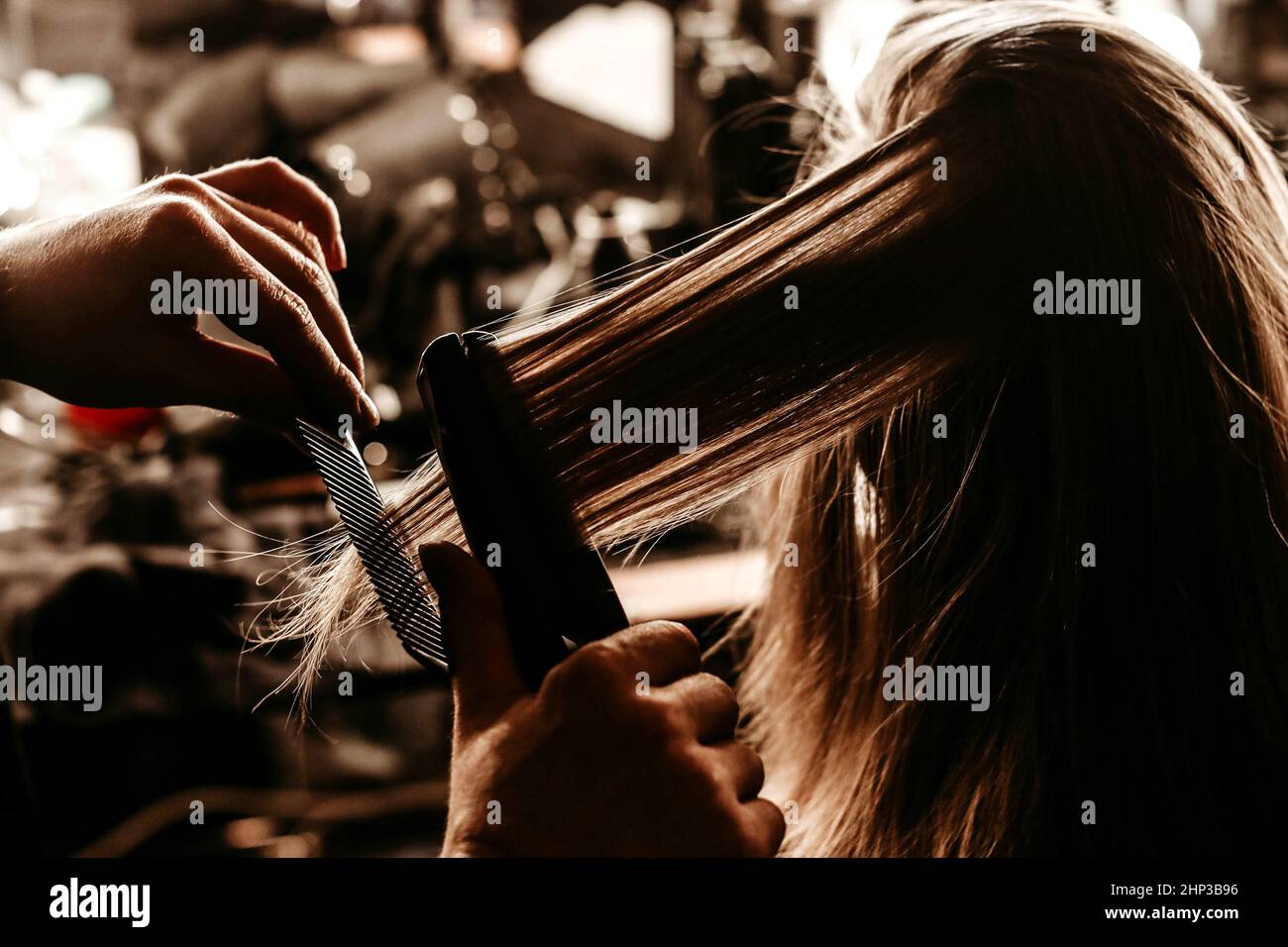 Weibliche Hände, die während der Fashion Week die Haare eines jungen blonden Models hinter der Bühne stylen Stockfoto