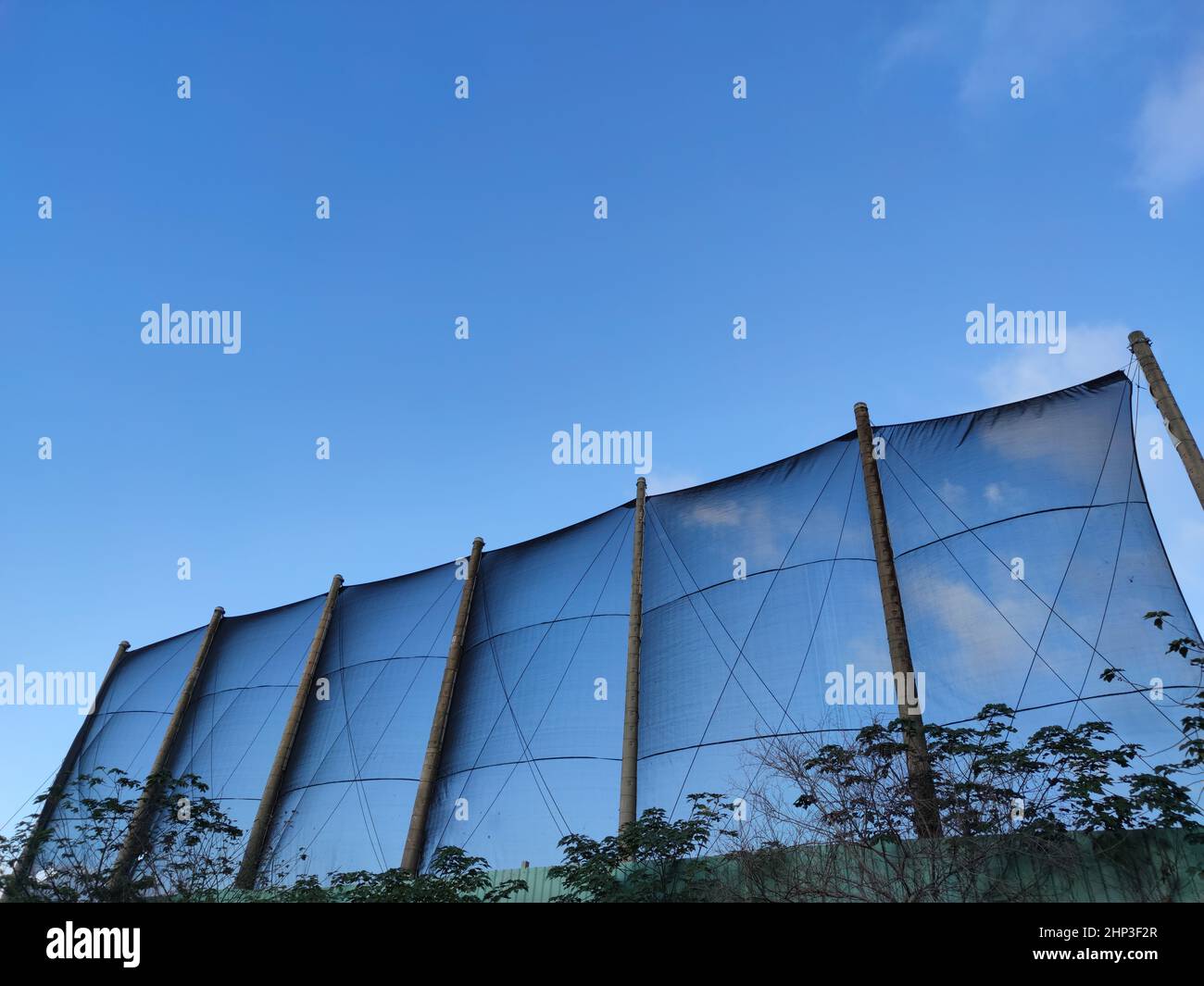 Das Netz gegen den blauen Himmel. Wunderschöne Zirruswolken. Schöne Cirrus Wolken über dem Sportplatz Stockfoto