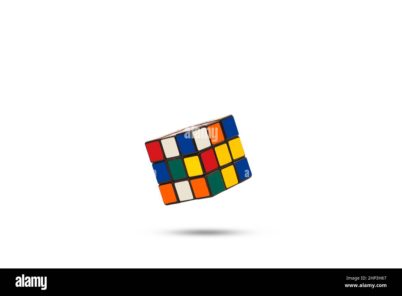 Ein Rubik-Würfel, der auf einem weißen Hintergrund mit Kopierfläche schwimmt Stockfoto