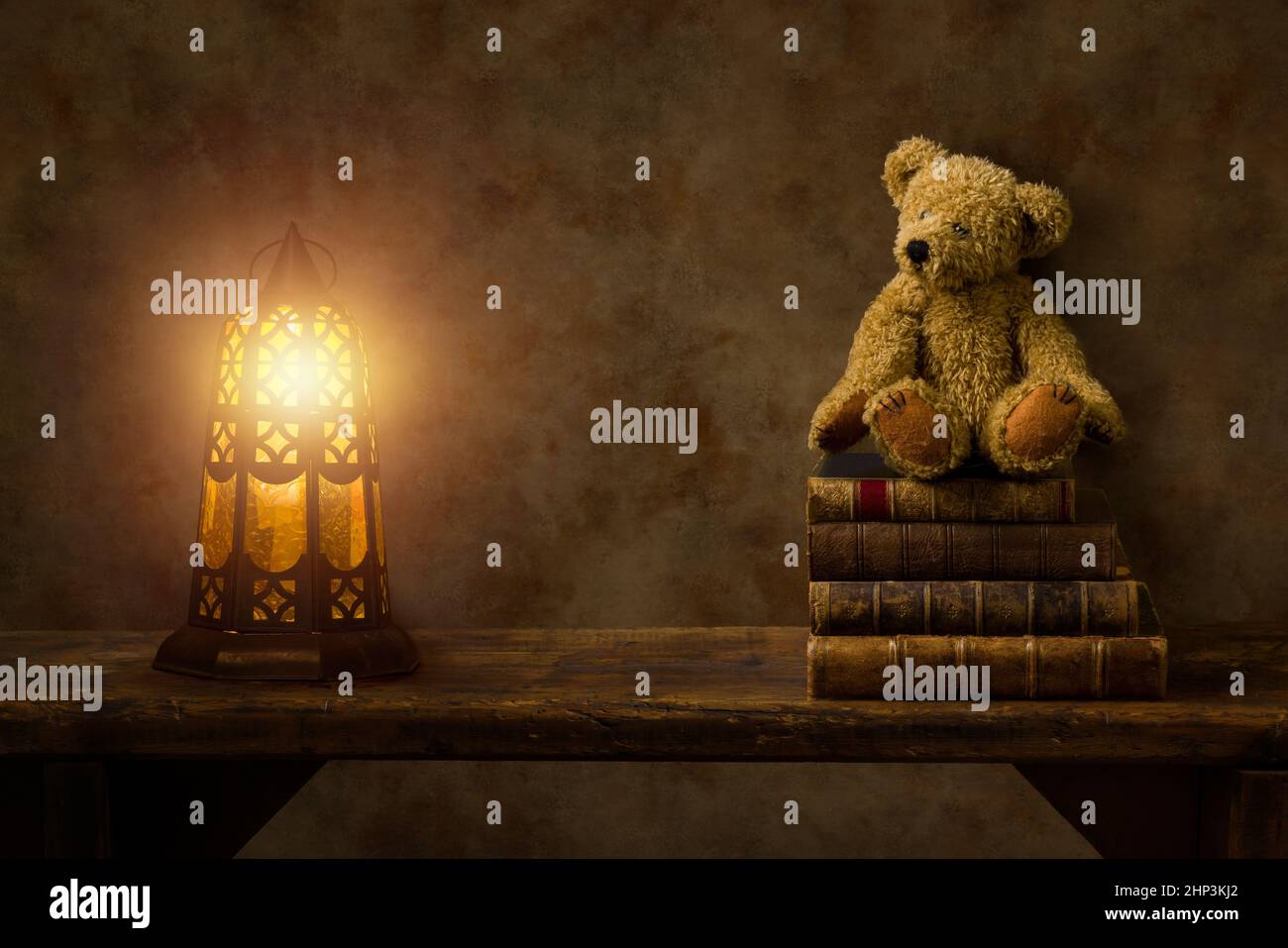 Brennende Laterne und Teddybär auf einem rustikalen alten Holzregal. Dies ist für digitales Compositing geeignet. Stockfoto