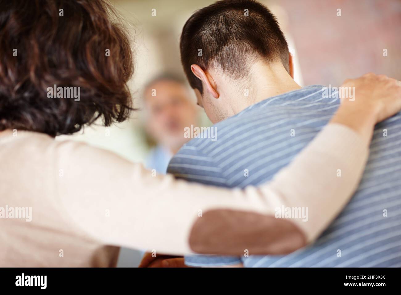 Waren alle für Sie da. Eine Rückansicht einer fürsorglichen Mutter, die ihren erwachsenen Sohn tröstet. Stockfoto