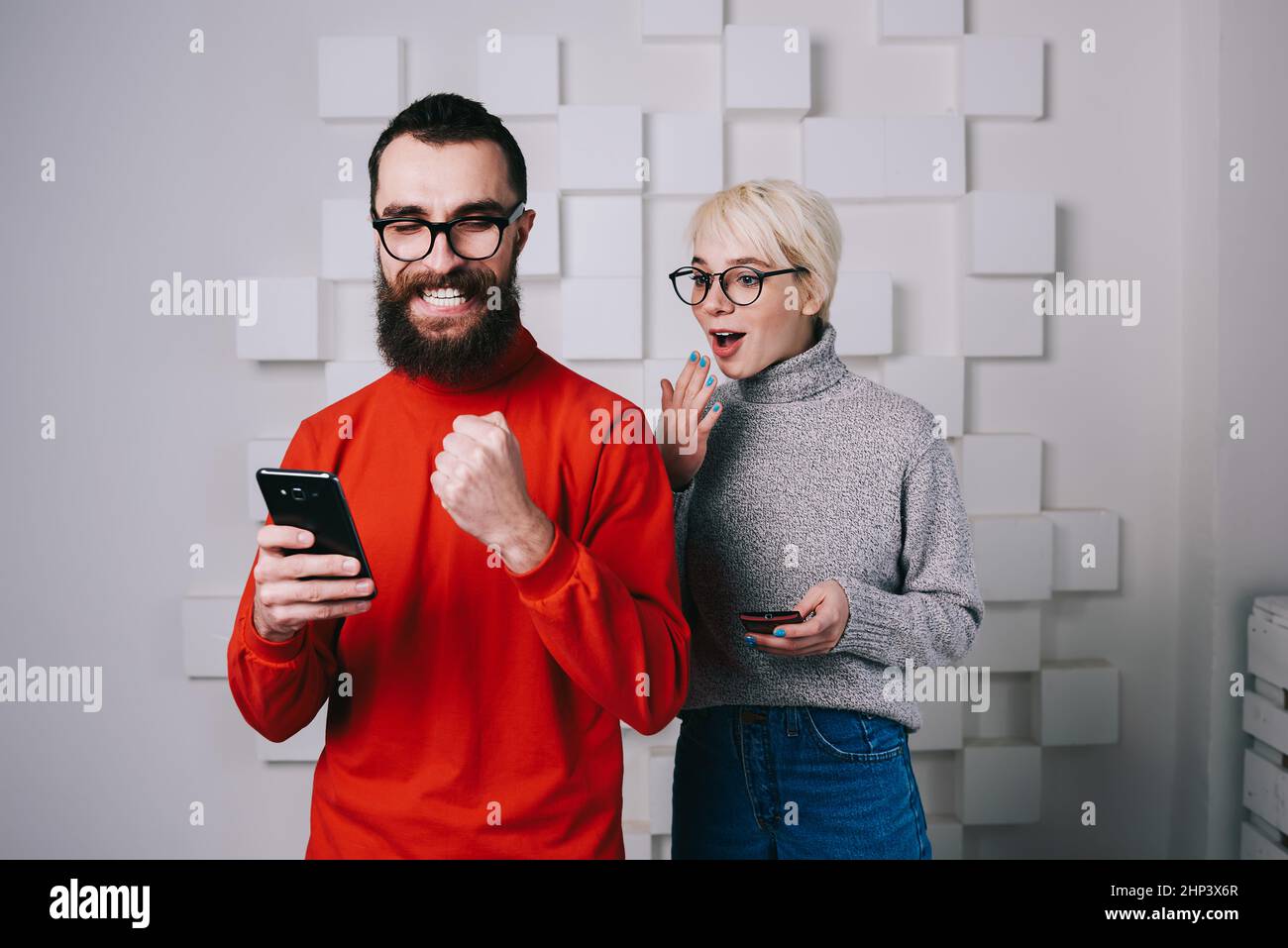 Fröhlicher Mann und Frau lesen gute Nachrichten auf dem Smartphone Stockfoto