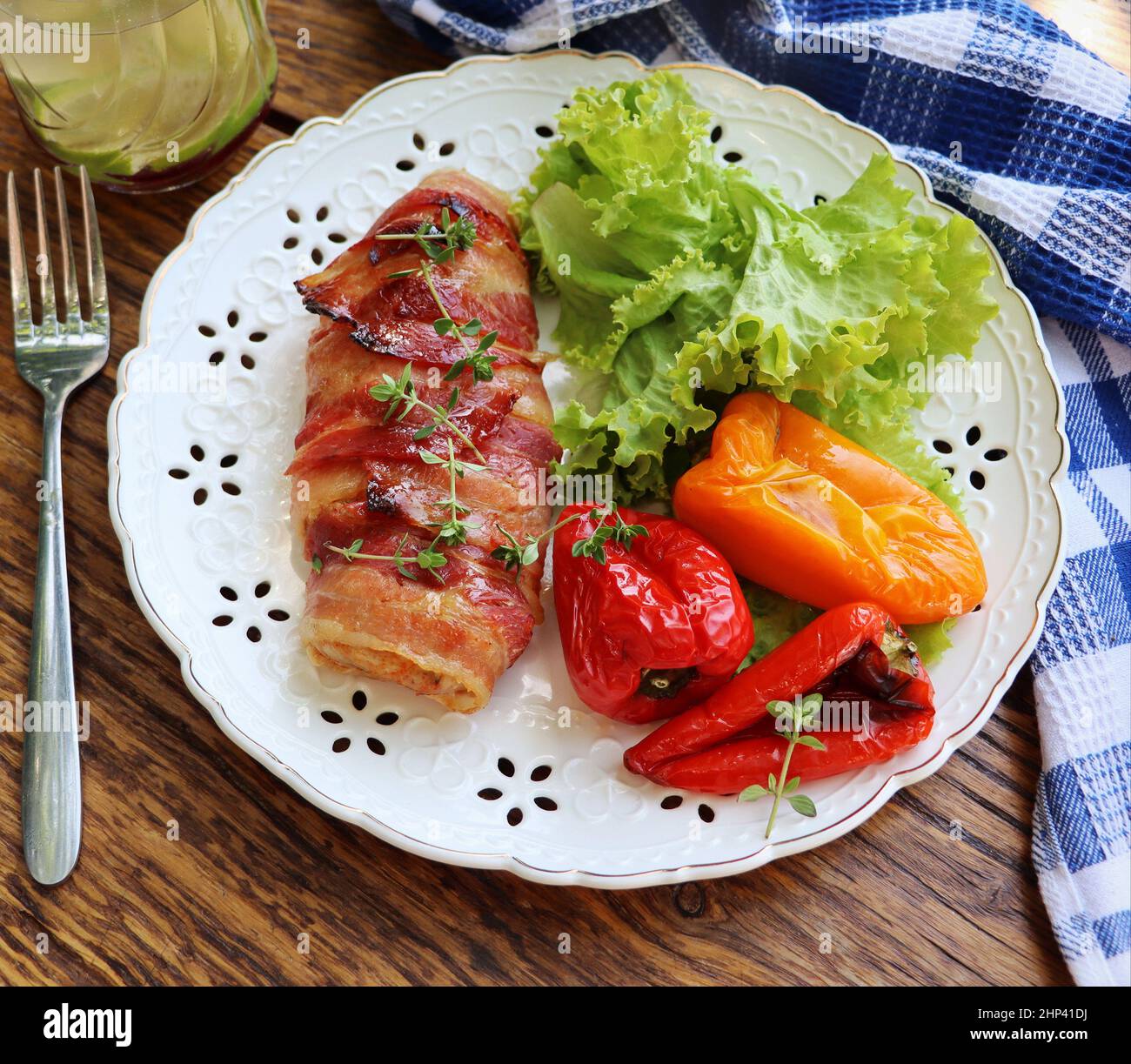 Abendessen im Hintergrund. Gegrillte Hähnchenbrust in Speck in der Pfanne auf Holz rustikalen Tisch eingewickelt. Draufsicht . Stockfoto