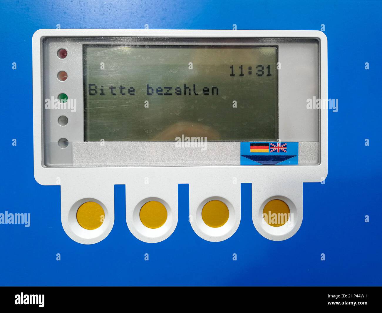 LCD-Bedienfeld und Funktionstasten einer blauen Parkuhr mit der Meldung „prompte Zahlung erforderlich“ in deutscher Sprache Stockfoto