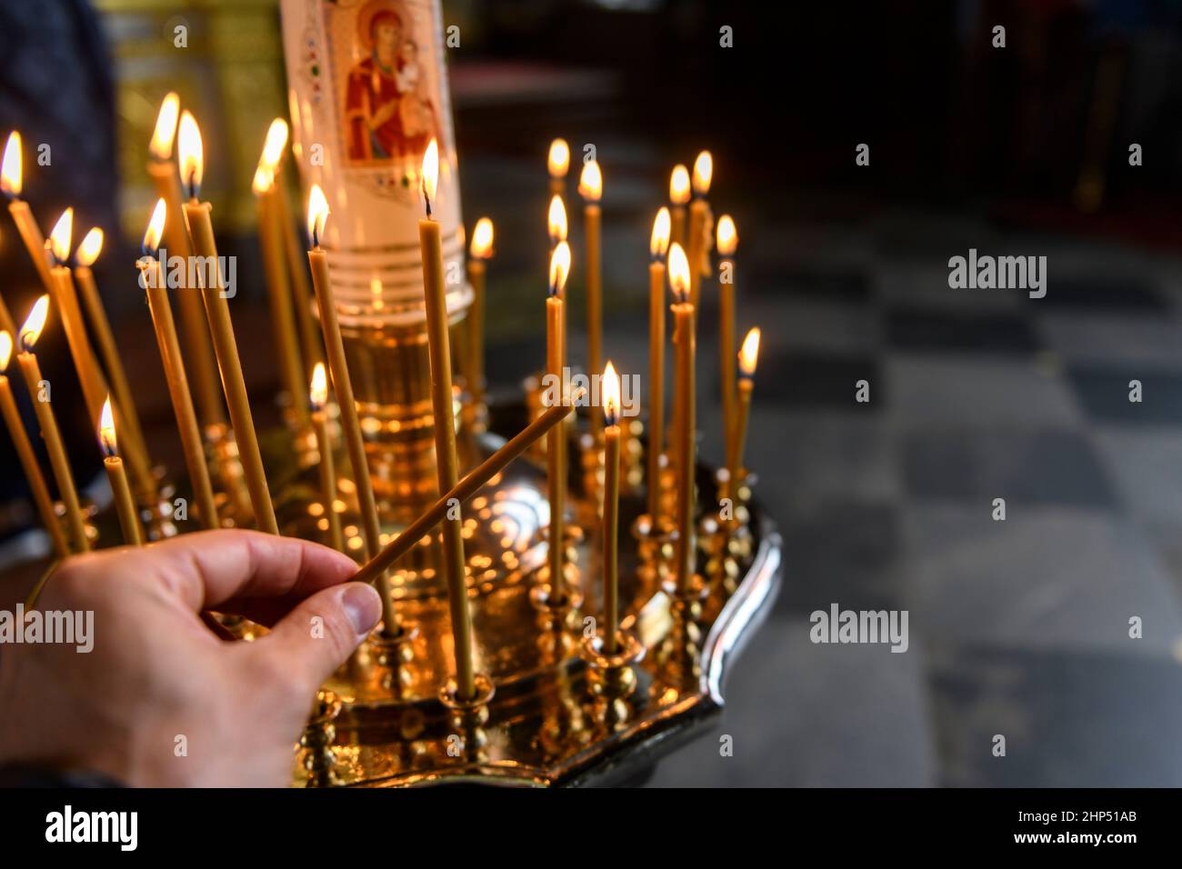 Kerzen in der russisch-orthodoxen Kathedrale mit Ikonen auf dem  Hintergrund. Kerze mit der Hand Stockfotografie - Alamy