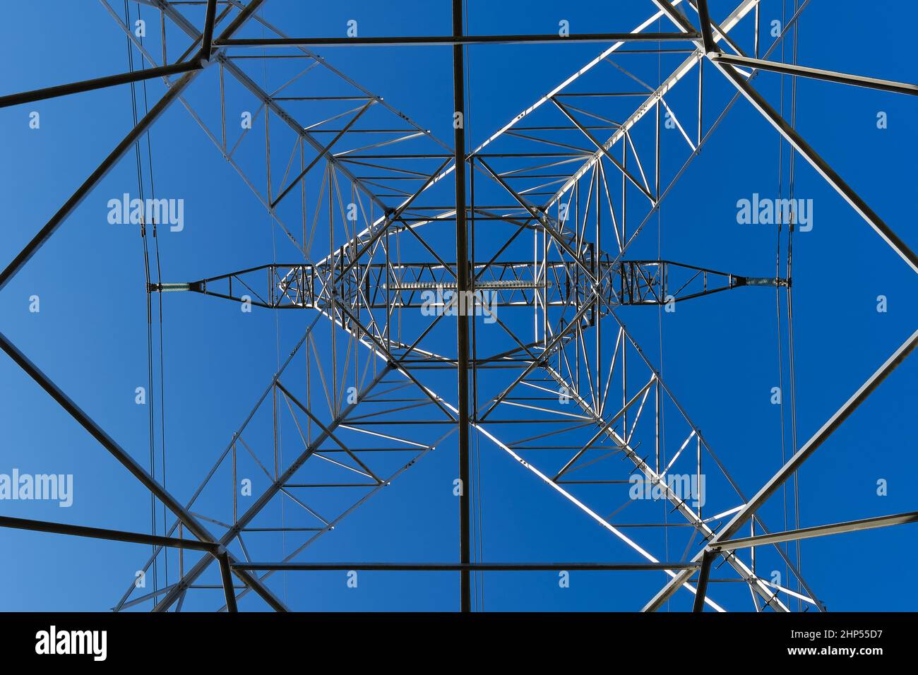 Hochspannungsturm von unten mit blauem Himmel Stockfoto