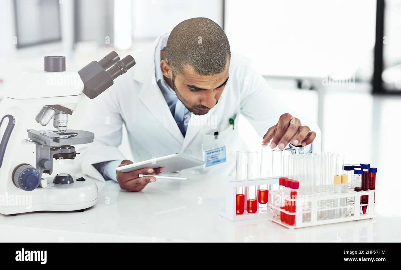 Er verfügt über gute praktische und technische Fähigkeiten. Aufnahme eines Wissenschaftlers, der ein mit Blut gefülltes Reagenzglas untersucht. Stockfoto