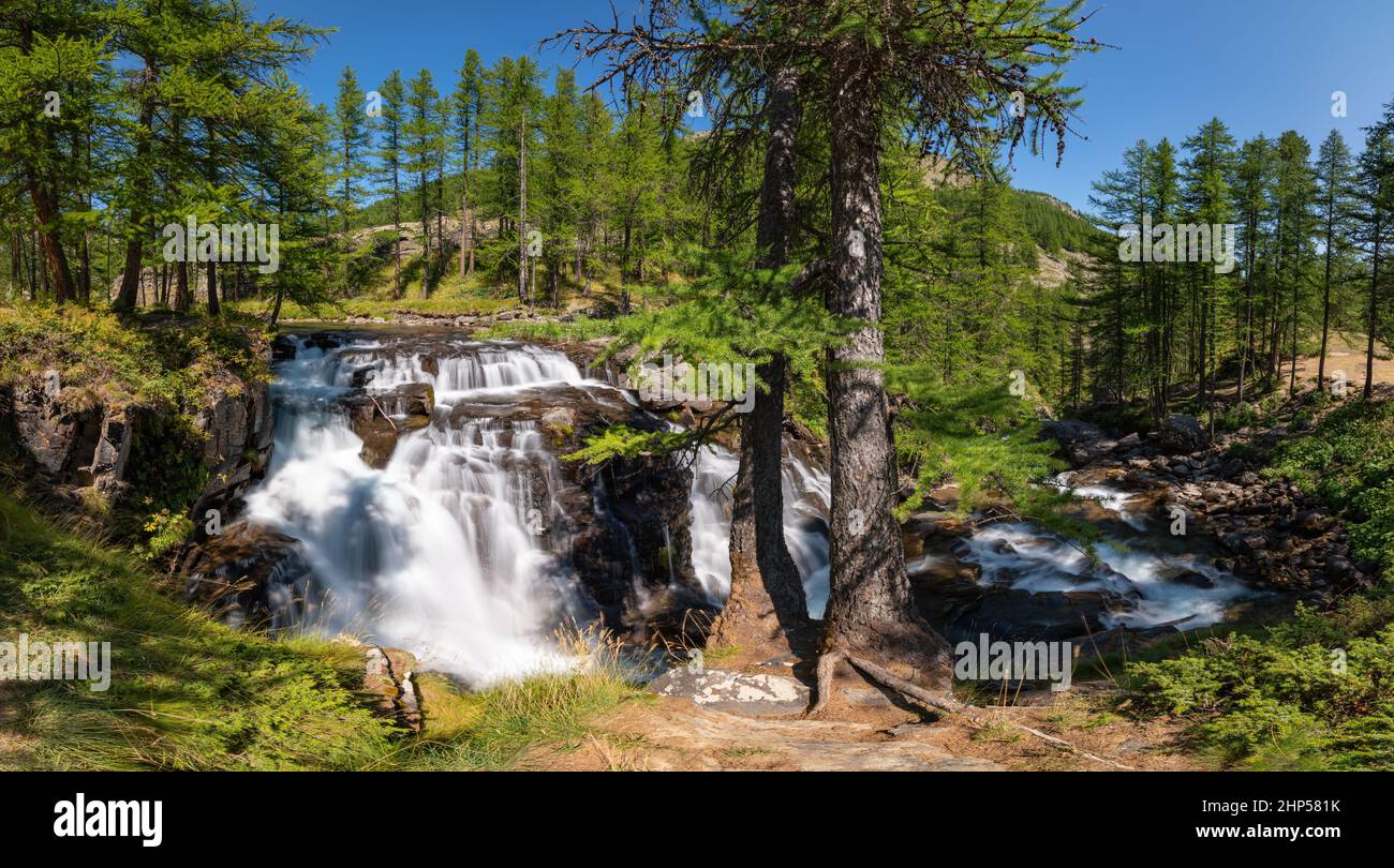 Fontcouverte Wasserfall im Tal von Claree im Sommer von Lärchen umgeben. Vallée de la Clarée in Hautes Alpes (Cerces Massif), Alpen, Frankreich Stockfoto