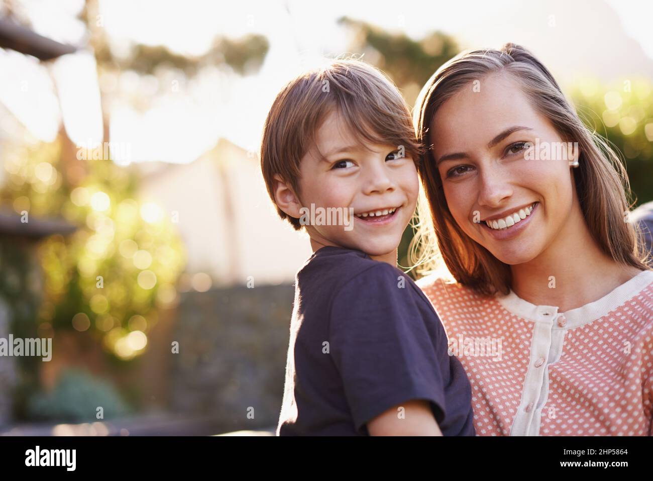 Die Hölle wird schon zu lange wachsen. Porträt einer glücklichen jungen Mutter und ihres entzückenden Sohnes, der draußen im Garten steht. Stockfoto