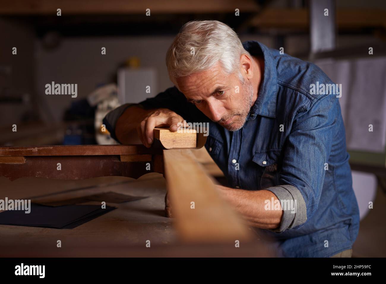 Holzbearbeitung pro. Aufnahme eines reifen männlichen Zimmermanns, der in seiner Werkstatt an einem Projekt arbeitet. Stockfoto