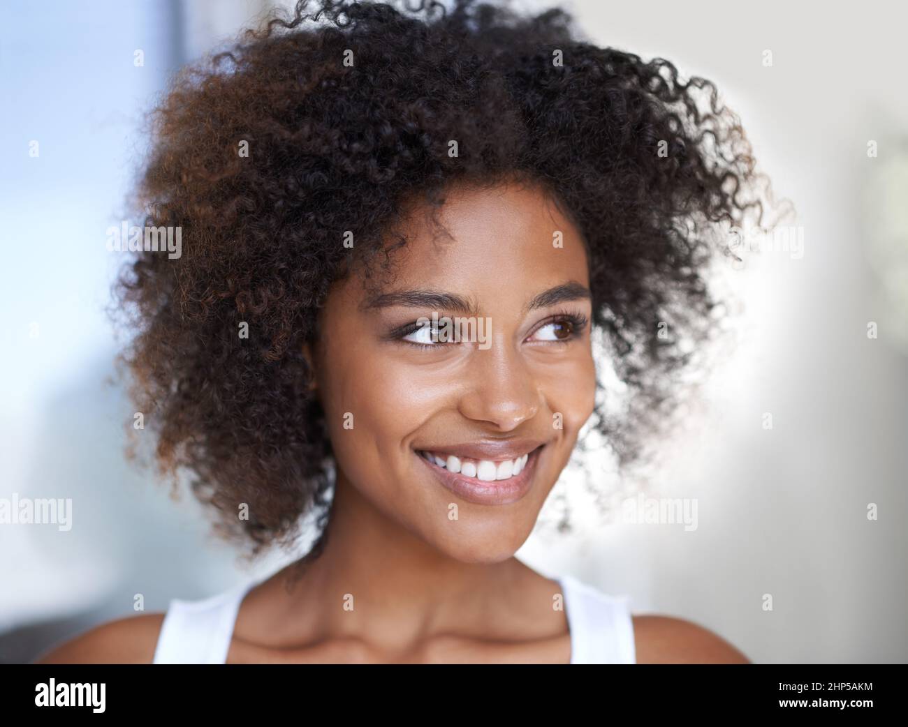 Frohe Gedanken. Aufnahme einer attraktiven jungen Frau, die in ihrem Haus nachdenklich aussieht. Stockfoto
