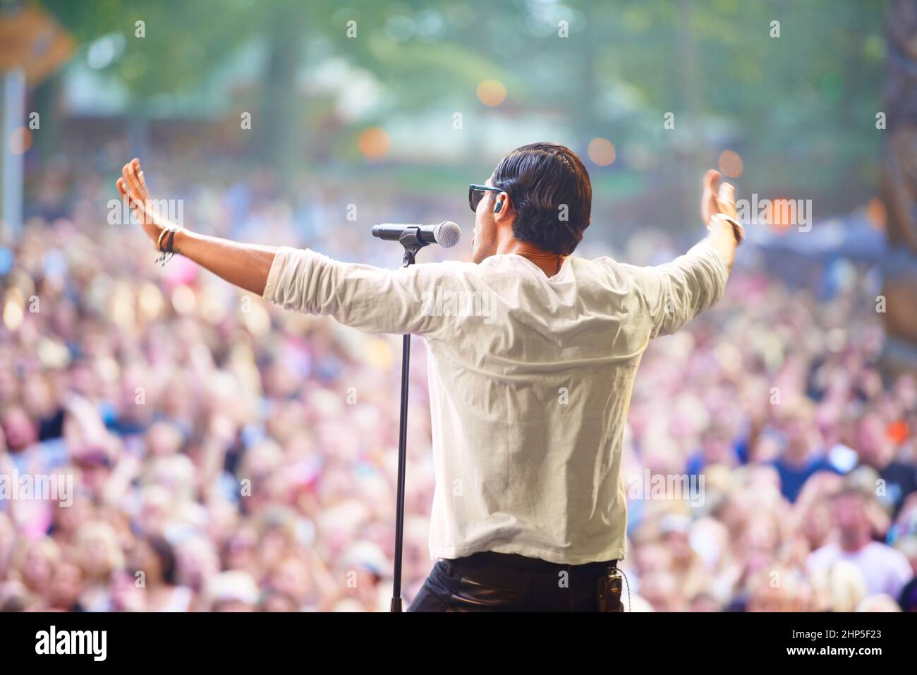 Charismatischer Frontmann. Eine Sängerin, die auf der Bühne eines Musikfestivals im Freien auftrat. Stockfoto