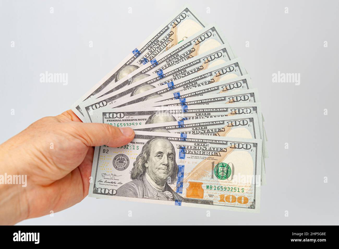 Nahaufnahme der Hand, die neun US-Dollar-Bill auf weißem Hintergrund mit Kopierraum isoliert hält. Stockfoto