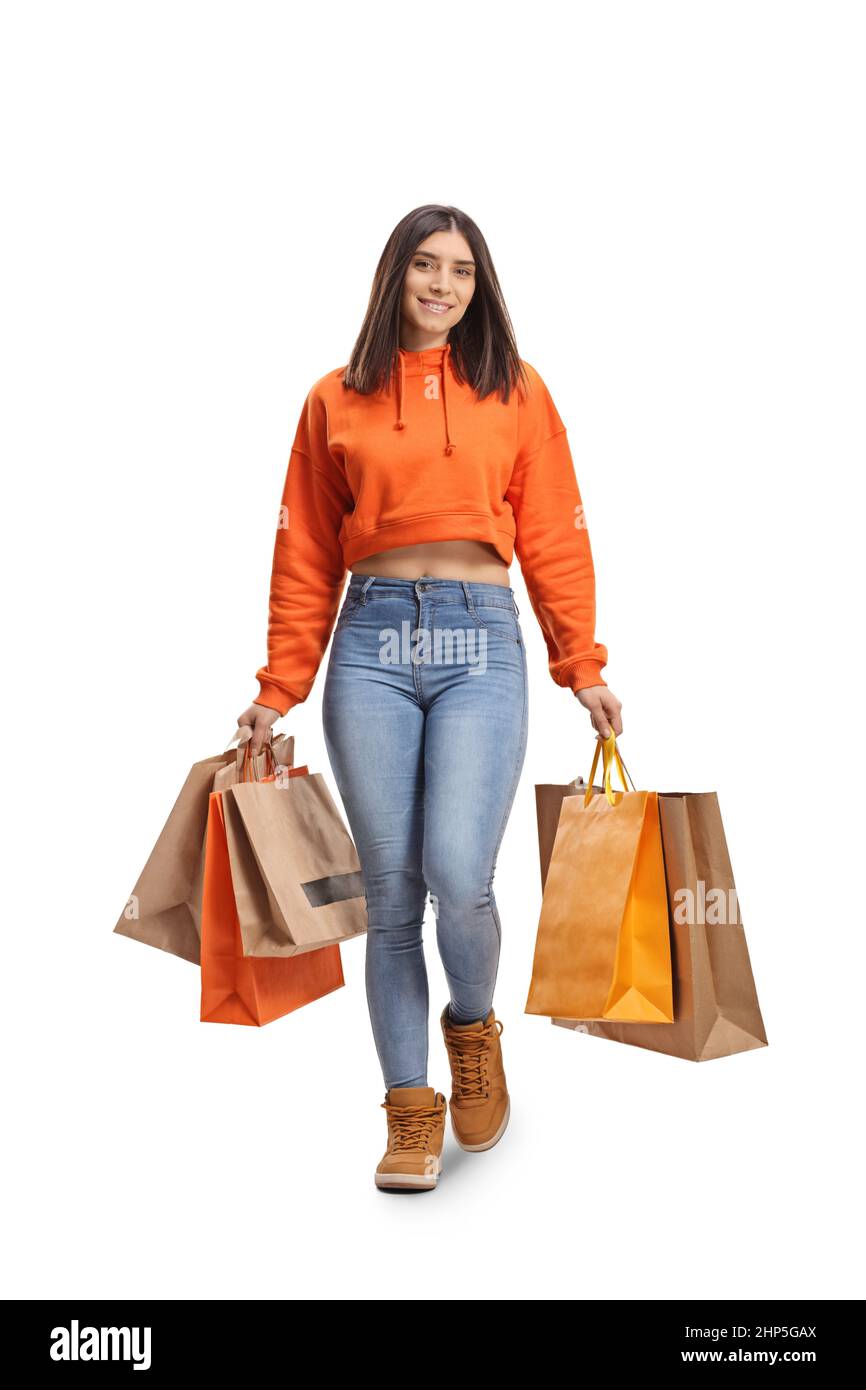 In voller Länge Porträt einer jungen trendigen casual weiblich zu Fuß in Richtung Kamera mit Einkaufstaschen isoliert auf weißem Hintergrund Stockfoto