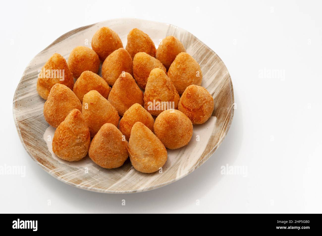 Typische brasilianische Vorspeise namens Coxinha de Frango isoliert auf weißem Hintergrund - Copy Space. Stockfoto