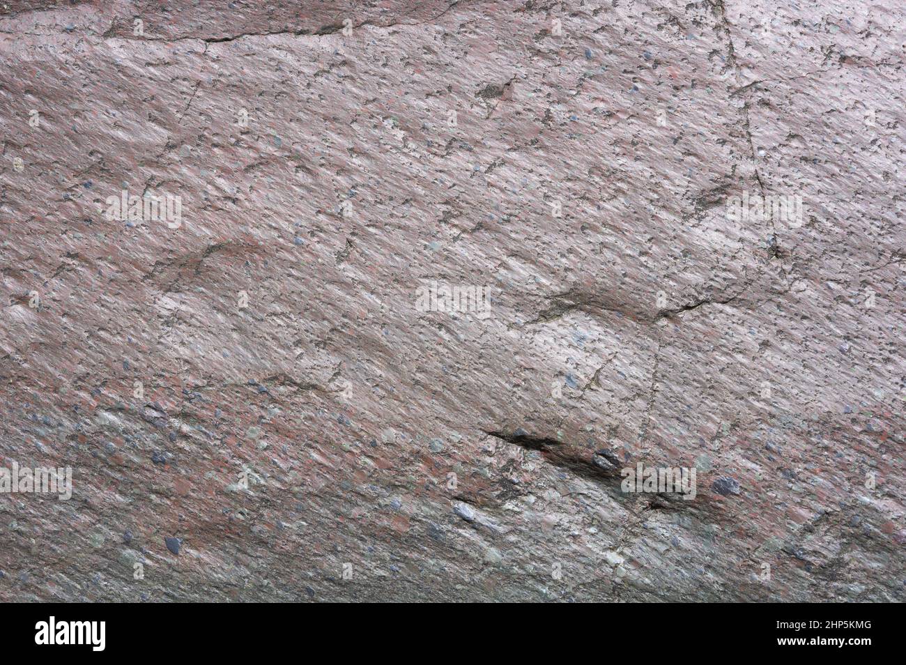 Das Foto zeigt die Textur des Steins. Das Steinmuster ist aus rosa Marmor. Traf Stein in der Wildnis in den Bergen der karibischen Insel. Die Oberfläche des Steins ist glatt. Stockfoto