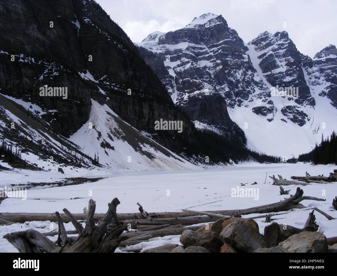 Schneebedeckte Gipfel und gefrorener Moraine Lake im Banff National Park im Frühling Stockfoto