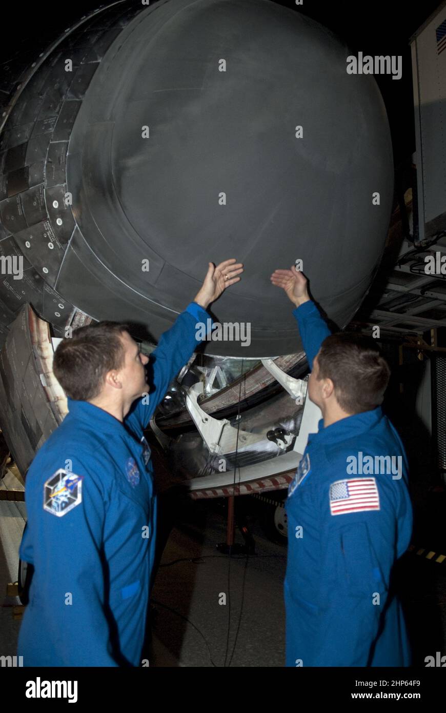 STS-130 die Missionsspezialisten Nichola Patrick, links, und Robert Behnken überprüfen die Temperatur des Nosecons des Weltraumshuttles Endeavour nach seiner erfolgreichen Landung auf der Start- und Landebahn 15 an der Shuttle Landing Facility im Kennedy Space Center der NASA in Florida Ca. 2010 Stockfoto