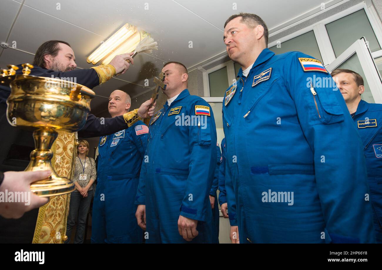 Expedition 47 Sojus-Kommandant Alexei Ovchinin von Roskosmos, Mitte, erhält den traditionellen Segen eines russisch-orthodoxen Priesters im Kosmonauten-Hotel vor seinem Start mit der Sojus-Rakete zur Internationalen Raumstation (ISS) am Freitag, den 18. März 2016 in Baikonur, Kasachstan. Ovchinin, der Flugingenieur Jeff Williams von der NASA, links, und der Flugingenieur Oleg Skripochka von Roscosmos, rechts, werden die nächsten fünfeinhalb Monate an Bord der ISS verbringen. Stockfoto