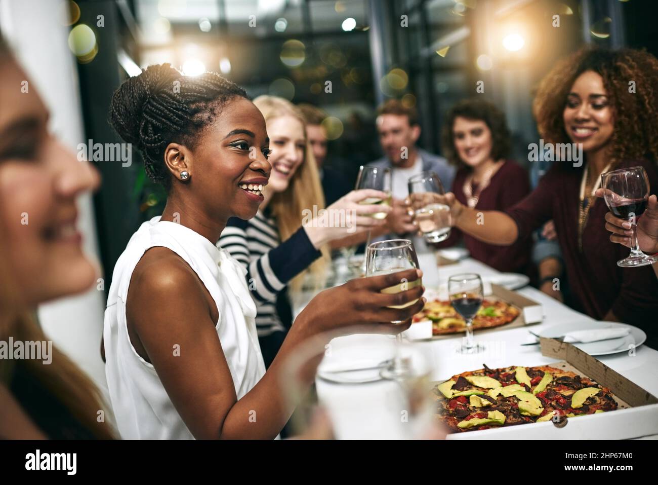 Alles ist besser, wenn man es mit Freunden macht. Eine kurze Aufnahme einer Gruppe junger Freunde, die in einem Restaurant eine Dinnerparty feiern. Stockfoto