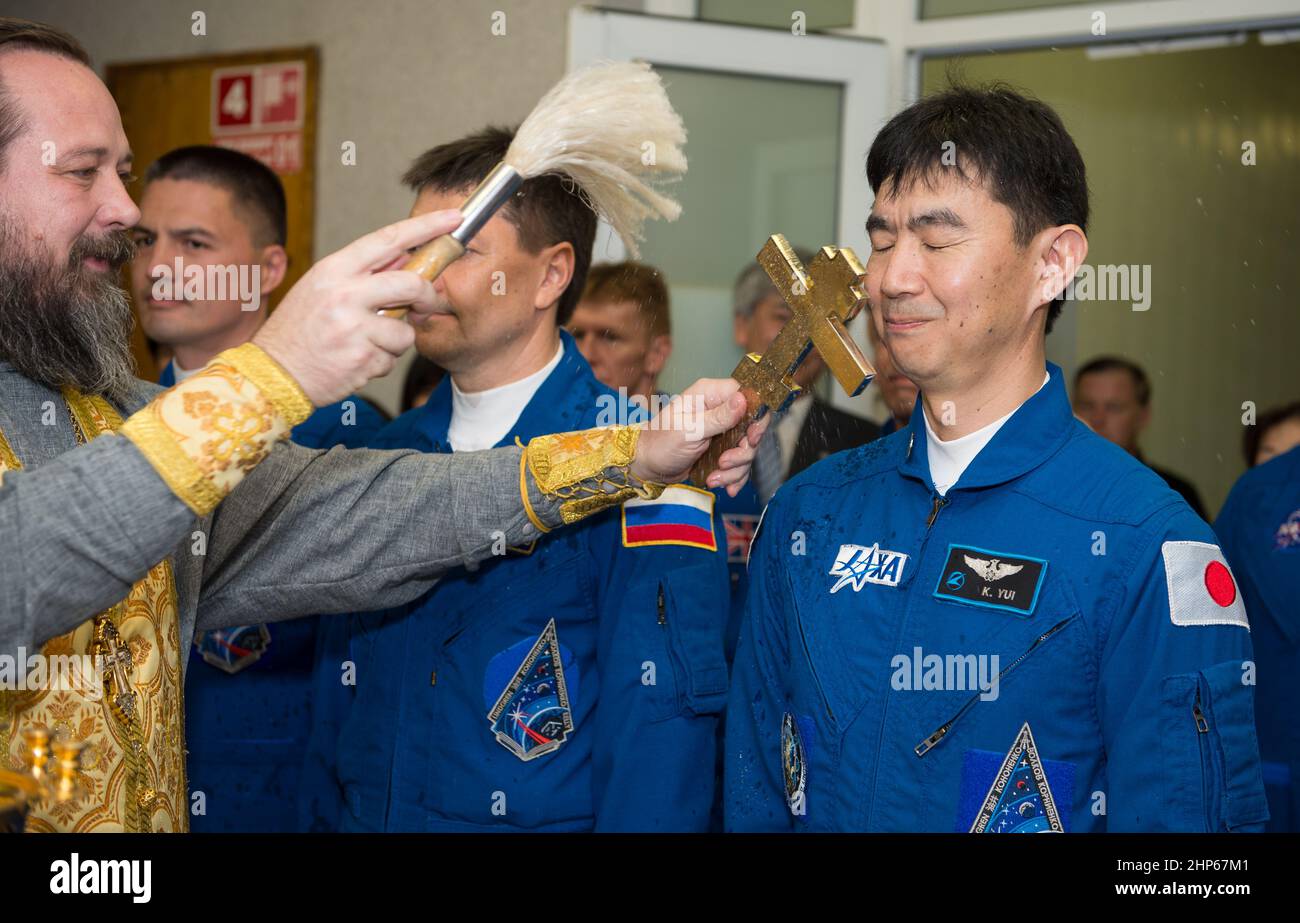 Expedition 44 der Flugingenieur Kimiya Yui von der Japan Aerospace Exploration Agency (JAXA), rechts, erhält den traditionellen Segen eines russisch-orthodoxen Priesters im Kosmonauten-Hotel vor seinem Start auf der Sojus-Rakete zur Internationalen Raumstation (ISS), Mittwoch, 22. Juli 2015, in Baikonur, Kasachstan. Stockfoto