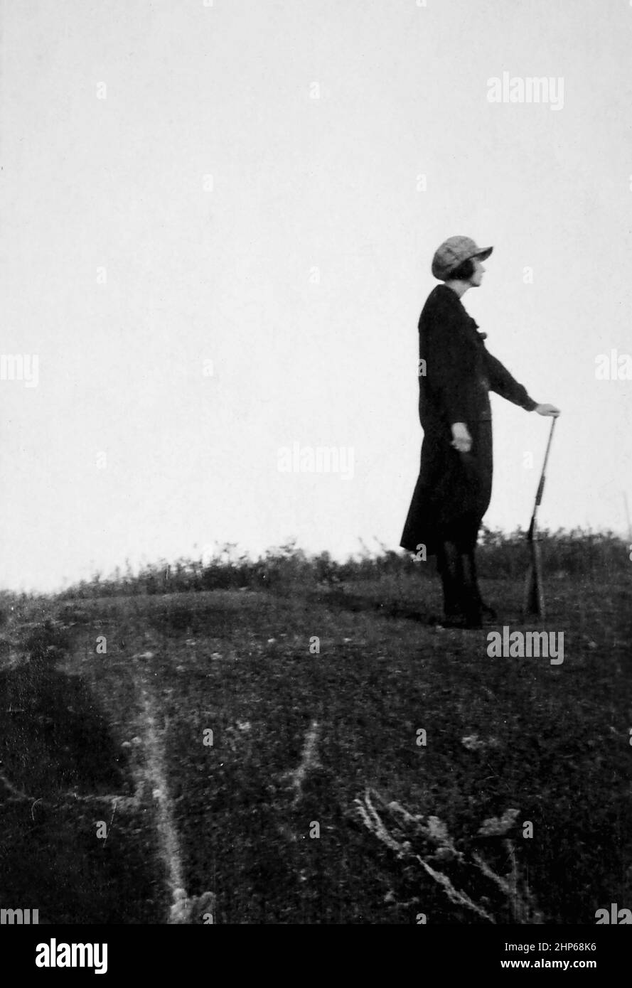 Eine Frau steht allein auf einem Hügel und hält ihr Gewehr, Ca. 1940. Stockfoto Eine Frau steht allein auf einem Hügel und hält ihr Gewehr, Ca. 1940. Stockfoto