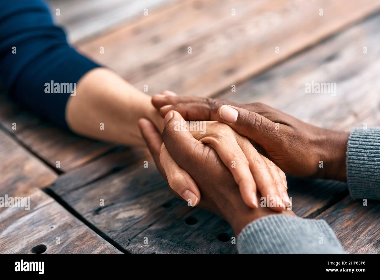 Ich finde Trost, wenn ich mit euch zusammen bin. Zugeschnittene Aufnahme von zwei nicht erkennbaren Personen, die sich die Hände hielten. Stockfoto