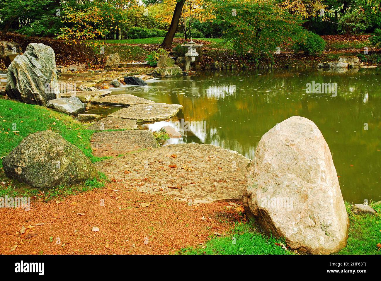 Herbstblätter umgeben einen ruhigen Garten im japanischen Stil Stockfoto